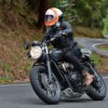 Man rides Triumph motorcycle through forest road in Australia